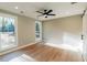Bright bedroom features hardwood floors, a ceiling fan, two windows, and a modern sliding barn door at 143 Harvest Way, Walterboro, SC 29488