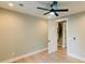 A bright bedroom features a ceiling fan, hardwood floors, and a doorway to a staircase at 143 Harvest Way, Walterboro, SC 29488