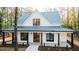Charming two-story home with a metal roof, wood porch columns, and meticulously landscaped front yard at 143 Harvest Way, Walterboro, SC 29488