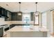 Modern kitchen features gray cabinets, pendant lighting, a large island, and stainless steel appliances at 143 Harvest Way, Walterboro, SC 29488