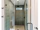 Modern glass enclosed shower features gray tiled walls, a rain shower head, and a mosaic tiled floor at 143 Harvest Way, Walterboro, SC 29488