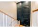 Elegant staircase with hardwood steps and white railing, adjacent to stylish, dark paneled wall at 143 Harvest Way, Walterboro, SC 29488