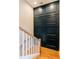 Elegant staircase with hardwood steps and white railing, adjacent to stylish, dark paneled wall at 143 Harvest Way, Walterboro, SC 29488