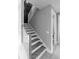 Monochrome image of a modern staircase with wood treads, white risers, and a contrasting dark accent wall at 143 Harvest Way, Walterboro, SC 29488