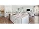 Open-concept kitchen and living space featuring white cabinets, spacious island with seating, and stainless steel appliances at 1437 Clay Field Trl, Summerville, SC 29485
