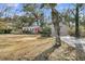 Cozy home with a bright red door, surrounded by lush trees and a well-kept lawn at 1521 Lynton Ave, Charleston, SC 29412