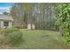 Large backyard featuring a wooden shed, mature trees, and lush green lawn, offering a private outdoor space at 158 Commons Way, Goose Creek, SC 29445