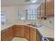 Kitchen featuring stainless steel sink and laminated countertops with wood cabinetry at 158 Commons Way, Goose Creek, SC 29445