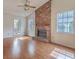Spacious living room featuring a brick fireplace, wood flooring and large windows allowing for ample natural light at 158 Commons Way, Goose Creek, SC 29445