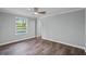 This bedroom offers neutral walls, a ceiling fan, wood-look floors, and a large sunlit window at 1657 Short Cut Rd, Cross, SC 29436