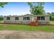 Exterior view of this charming home featuring a small wood porch and a well-manicured lawn at 1657 Short Cut Rd, Cross, SC 29436