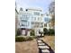Stunning multi-story white home featuring dual balconies, meticulous landscaping, and a charming stepping stone walkway at 172 Mary Ellen Dr, Charleston, SC 29403