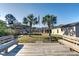Expansive backyard with mature palm trees, sitting area and covered boat storage, ideal for outdoor living at 1886 Capri Dr, Charleston, SC 29407