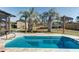 Inviting swimming pool surrounded by lush palm trees and a serene backyard setting at 1886 Capri Dr, Charleston, SC 29407