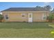 A view of the back of the house and the back yard, with grass and trees at 191 Blackstone Dr, Moncks Corner, SC 29461