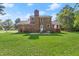 Expansive brick home backyard featuring a well-maintained lawn, patio, and classic brick facade at 203 Horseshoe Rd, Moncks Corner, SC 29461