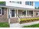 Inviting front porch with brick facade, complemented by neat landscaping and classic design elements at 203 Horseshoe Rd, Moncks Corner, SC 29461