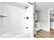 Bathroom with white tiled shower, black fixtures, wood-look flooring and modern vanity at 204 Delano St, Saint George, SC 29477