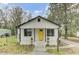 Charming bungalow with a bright yellow front door, black trim and a cozy front porch at 204 Delano St, Saint George, SC 29477