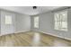 Bright living room with new wood flooring, a white front door and three windows at 204 Delano St, Saint George, SC 29477