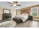 This bedroom has a wooden accent wall, ceiling fan, and dark furniture on a wood floor at 233 Old Carolina Dr, Goose Creek, SC 29445