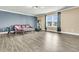 Comfortable living room features wood floors, neutral paint and a fitness machine by the window at 233 Old Carolina Dr, Goose Creek, SC 29445
