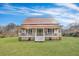 Charming historic home with a large front porch, featuring a vibrant green lawn and mature trees at 242 Weathers Farm Rd, Bowman, SC 29018
