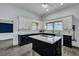 Open kitchen featuring an island, white cabinets, black lower cabinets, and neutral-toned countertops at 242 Weathers Farm Rd, Bowman, SC 29018