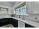 Well-lit kitchen with white cabinets, black lower cabinets, and neutral-toned countertops at 242 Weathers Farm Rd, Bowman, SC 29018