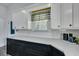 Well-lit kitchen with white cabinets, black lower cabinets, and neutral-toned countertops at 242 Weathers Farm Rd, Bowman, SC 29018