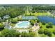 Overhead view showcasing a community pool, playground, sports courts, and a tranquil pond among landscaped grounds and mature trees at 2788 Carolina Isle Dr, Mount Pleasant, SC 29466