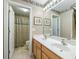 Bathroom featuring double sinks, framed art, and decorative wallpaper with a shower in the background at 2788 Carolina Isle Dr, Mount Pleasant, SC 29466