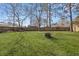 Spacious backyard with green grass, a fire pit, and a wooden fence perimeter at 2915 Nantuckett Ave, North Charleston, SC 29420