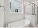 Bright bathroom featuring a soaking tub and a glass shower, with natural light from a window at 3154 Vanessa Lynne Ln, Johns Island, SC 29455