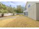 A expansive backyard features a grassy lawn, a gravel path, and a white fence with trees at 3204 Waterway Blvd, Isle of Palms, SC 29451
