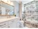 Elegant bathroom with a tiled shower, soaking tub, vanity, and decorative mirror at 3204 Waterway Blvd, Isle of Palms, SC 29451