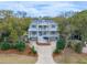 Stunning elevated home featuring multiple balconies, garage, landscaped yard, and driveway at 3204 Waterway Blvd, Isle of Palms, SC 29451