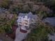 Aerial view of a lovely three-story home with a lush tree canopy surrounding this private property at 3204 Waterway Blvd, Isle of Palms, SC 29451