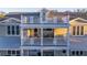 Balconies of this charming house feature outdoor seating, decor, and the exterior has ornate white railings at 3204 Waterway Blvd, Isle of Palms, SC 29451