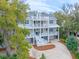 View of the three-story home with multiple decks and a well maintained yard at 3204 Waterway Blvd, Isle of Palms, SC 29451