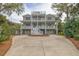 Charming three-story home boasts a welcoming facade, multiple balconies, and a spacious driveway at 3204 Waterway Blvd, Isle of Palms, SC 29451