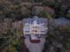 Overhead view of a beautiful three-story home with staircases and a private drive surrounded by mature trees at 3204 Waterway Blvd, Isle of Palms, SC 29451