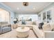 Spacious living room with a cozy sectional, bright windows, and a view into the modern kitchen, creating a welcoming atmosphere at 3204 Waterway Blvd, Isle of Palms, SC 29451