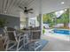 Relaxing covered patio with a table and view of the inviting backyard pool and lounge area at 3204 Waterway Blvd, Isle of Palms, SC 29451