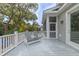 A screened-in porch with gray Adirondack chairs and view of the trees at 3204 Waterway Blvd, Isle of Palms, SC 29451