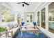 Inviting screened porch with plush seating, ceiling fan, and tranquil outdoor views through windows and doors at 3204 Waterway Blvd, Isle of Palms, SC 29451