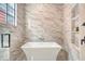Bathroom features marble tiling, a soaking tub, a rainfall shower head, and built-in shelving niche at 40 Pitt St, Charleston, SC 29401