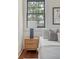 Cozy bedroom features a bedside table with a stylish lamp and black frame window providing natural light at 40 Pitt St, Charleston, SC 29401