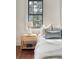 Bedroom with hardwood floors, a nightstand, two large windows, and white and blue decor accents at 40 Pitt St, Charleston, SC 29401