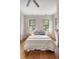 Charming bedroom features hardwood floors, neutral walls, and plenty of natural light from two large windows at 40 Pitt St, Charleston, SC 29401